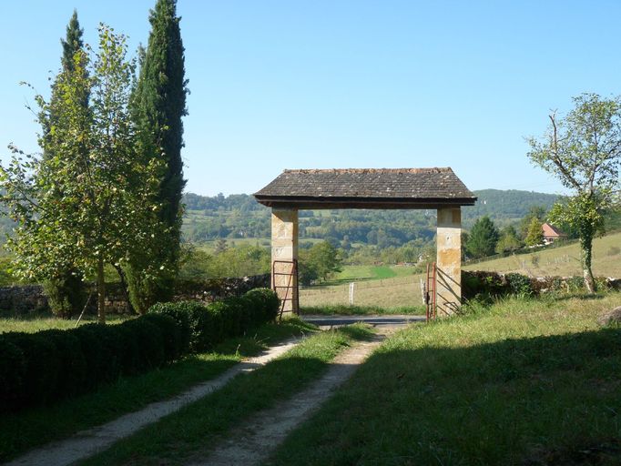 Vue du portail et de l'allée menant au château prise depuis le jardin.