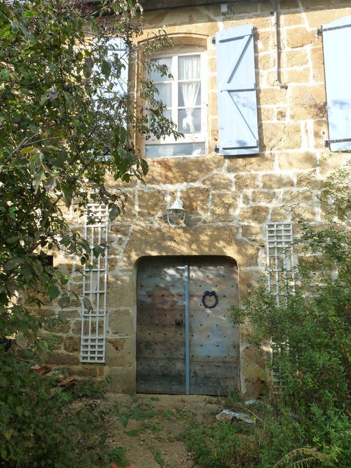 Détail d'un travée d'ouvertures de l'élévation postérieure. Porte piétonne à deux vantaux en arc déprimé surmontée d'une baie cintrée (18e siècle).