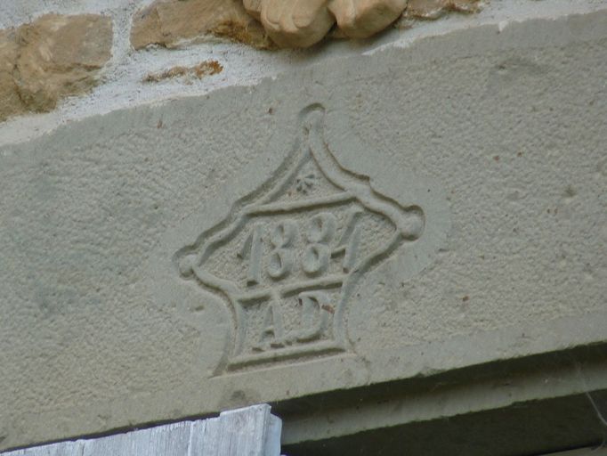 Façade principale. Détail de la date 1884 ornée des lettres A.D inscrite sur le linteau de la fenêtre du 1er étage.