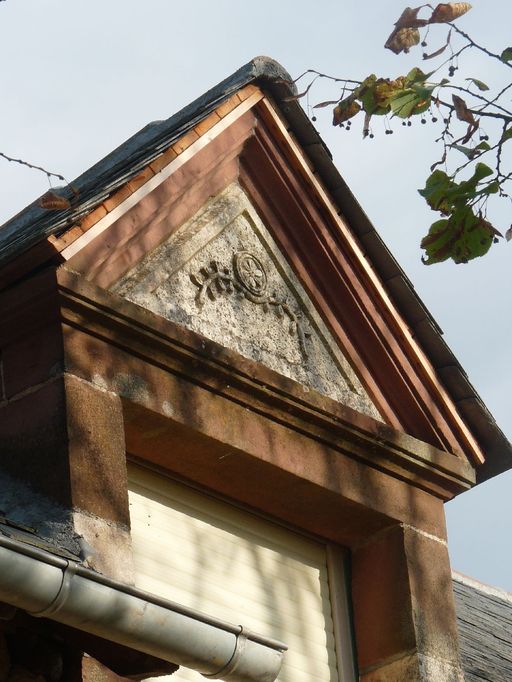 Détail du fronton de l'une des lucarnes à fronton-pignon installée sur le versant ouest du toit de la grange et décorée de rinceaux de lauriers et d'une étoile.