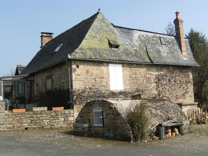 Vue générale du logis de la ferme et de la citerne maçonnée.