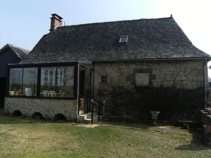 Logis. Façade principale nord-ouest, sur cour : baie à coussièges à encadrements en grès rouge, murée.