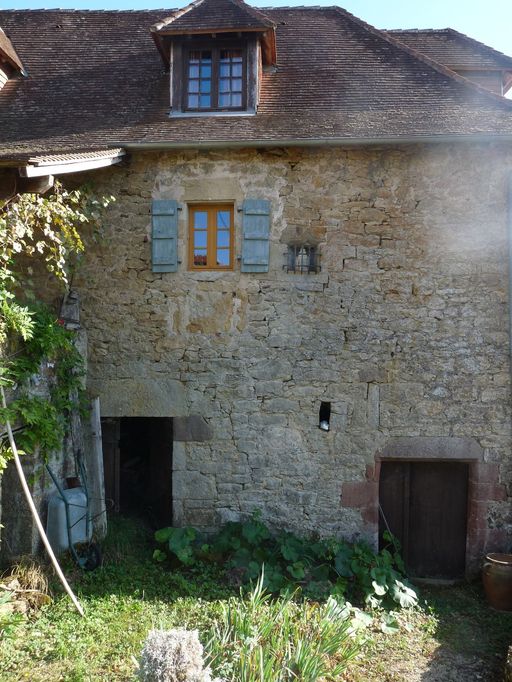 Elévation principale nord. Accès à l'étage de soubassement par une porte à encadrement droit et à la cave voûtée par une porte chanfreinée à encadrement en grès rouge.