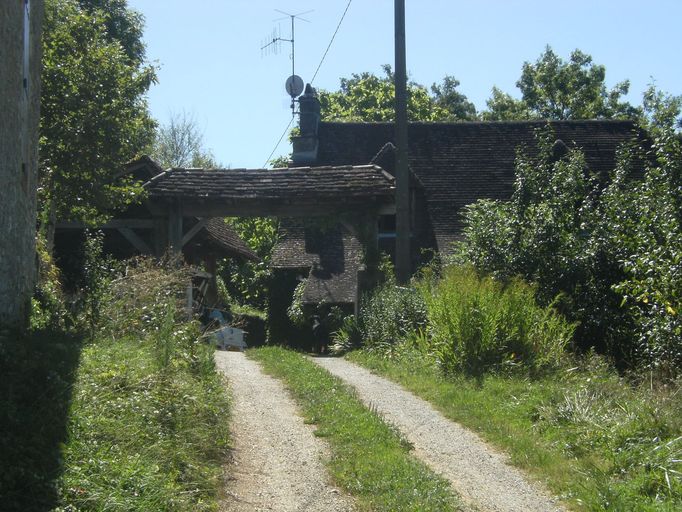 Vue générale prise depuis le chemin d'accès et du portail couvert de tuiles plates.
