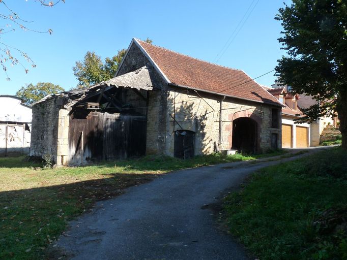 Vue générale de la grange-étable alignée le long de la voie publique.
