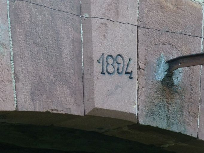 Détail de la date 1894 inscrite sur la clé de la porte charretière.