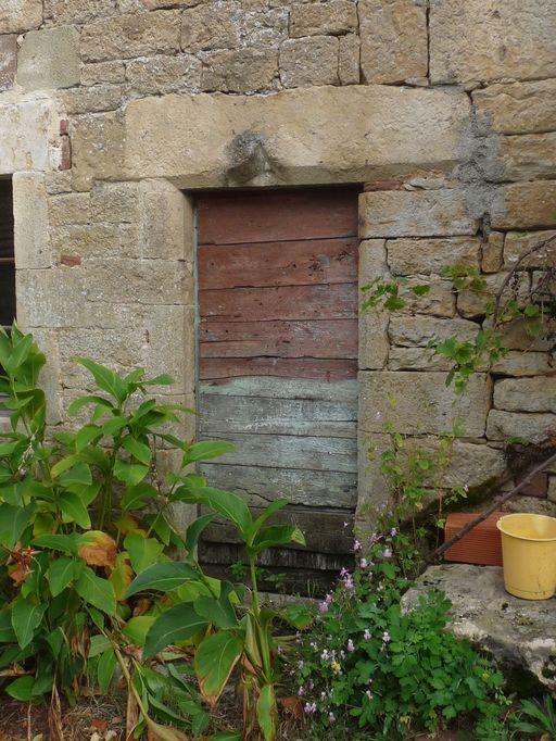 Elévation principale sud : détail de la porte piétonne de gauche surmontée d'un linteau en arc en accolade, en remploi.