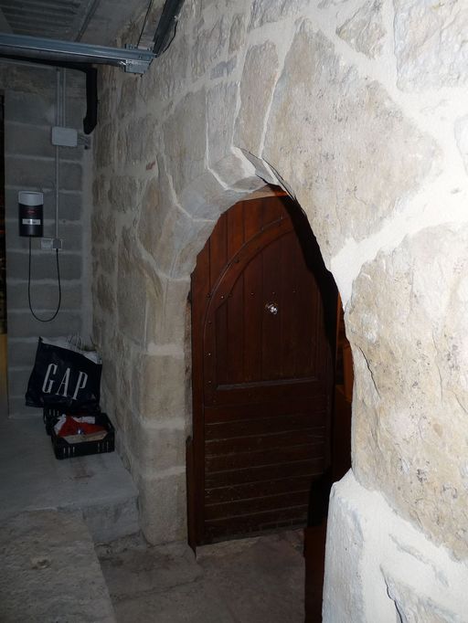 Mur-pignon ouest : porte en arc brisé donnant accès à la cave voûtée.