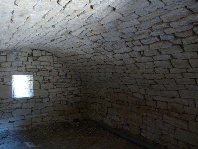 Cave voûtée en berceau édifiée en moellon de calcaire équarri.