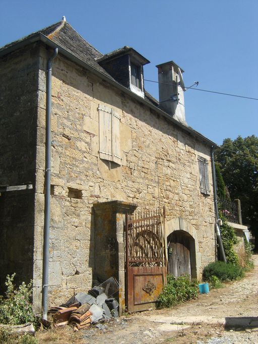 Vue générale de la façade principale sud-est du logis. Accès à l'étage de soubassement par une porte charretière en arc segmentaire à clé saillante.