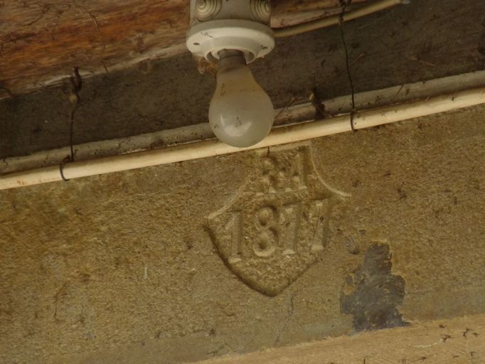 Détail du linteau de la porte d'entrée portant la date 1877 et les initiales R. A.