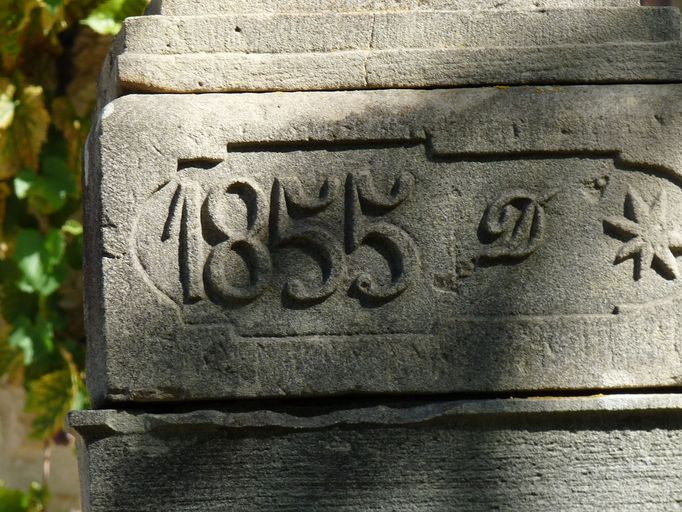 Pilier gauche du portail. Détail de la date 1855 suivie de la lettre D et d'une étoile.