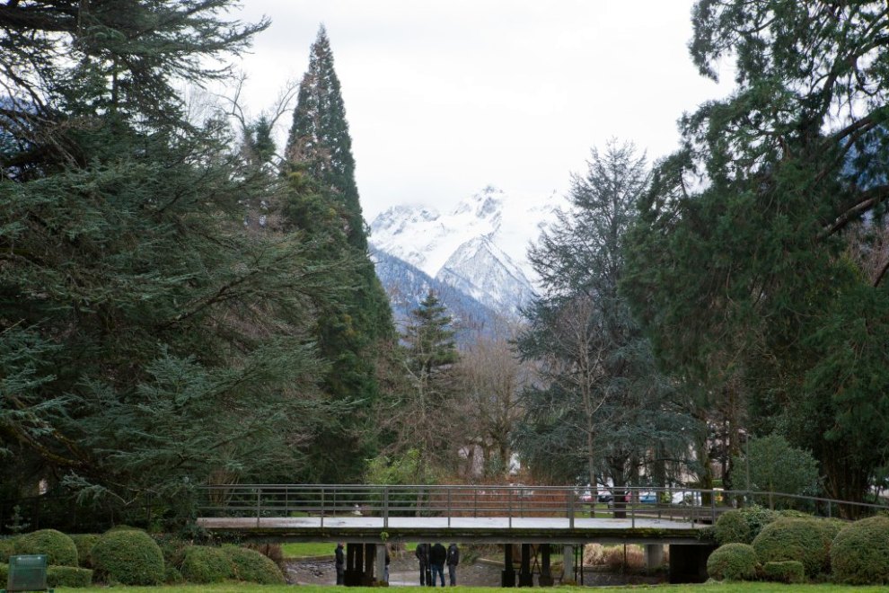 Vue hivernale de la pièce d'eau du parc du casino, encadrée par le cèdre de l'Atlas et le sequoia géant, avec la perspective sur la montagne.