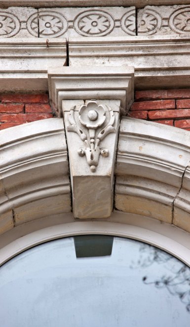 Détail de la clé d'une porte-fenêtre sur l'élévation postérieure de l'aile principale.