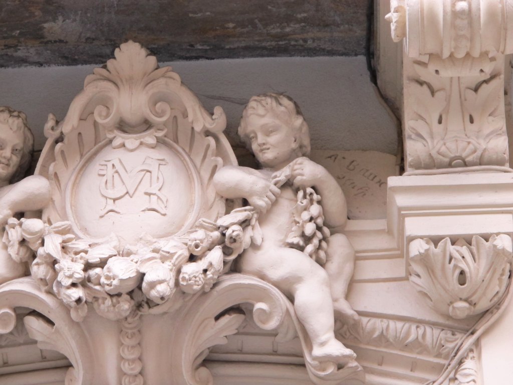 Décor de la porte d'entrée : détail de l'enfant à droite avec la signature de Baux à l'arrière-plan.