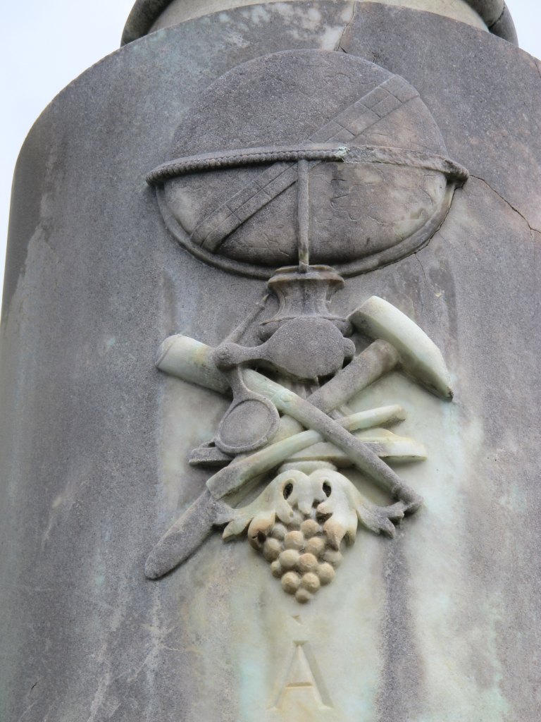 Détail des outils du géologue sculptés sur le fût de la colonne.