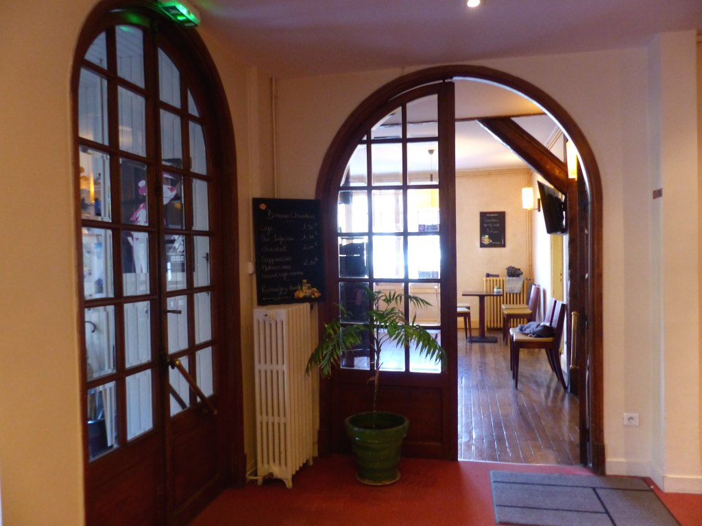 Accueil, vue de la porte d'entrée à gauche et de l'entrée du bar en face.
