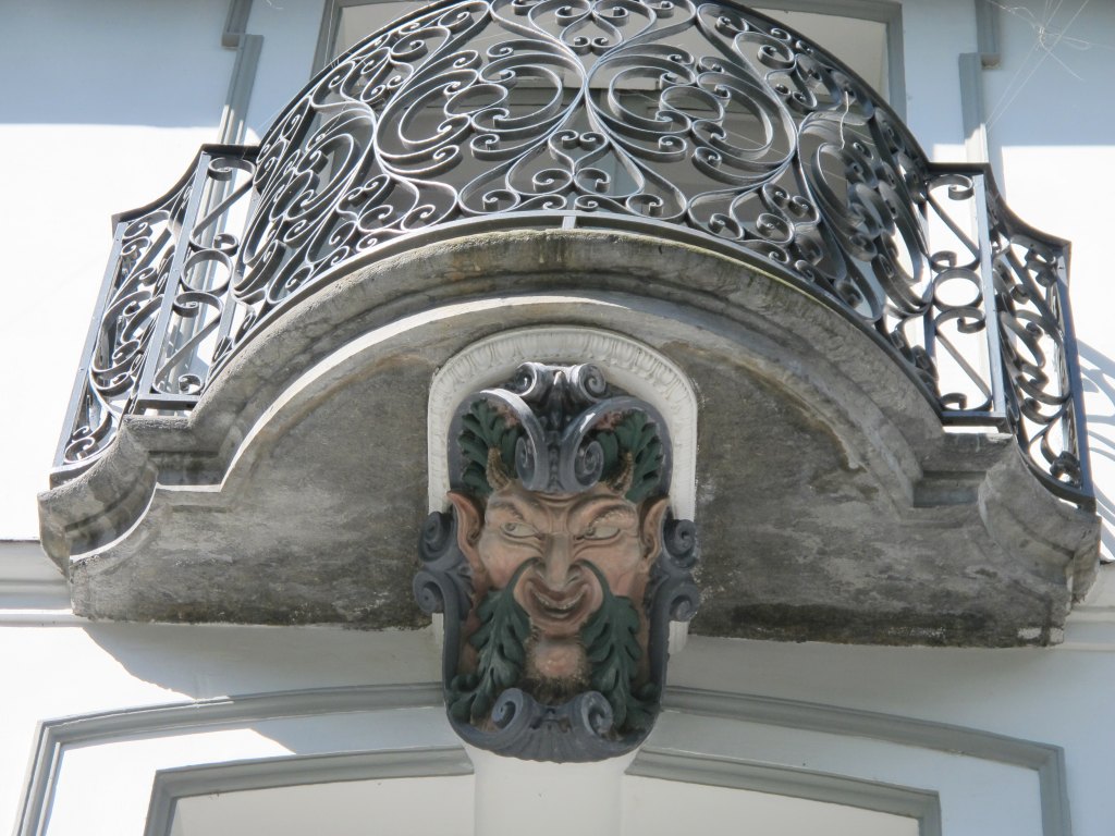 Détail du décor de masque de théâtre placé sous un balcon de l'étage.