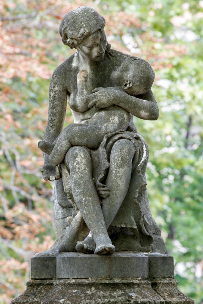Vue d'ensemble de face du groupe sculpté représentant une mère consolant son enfant.