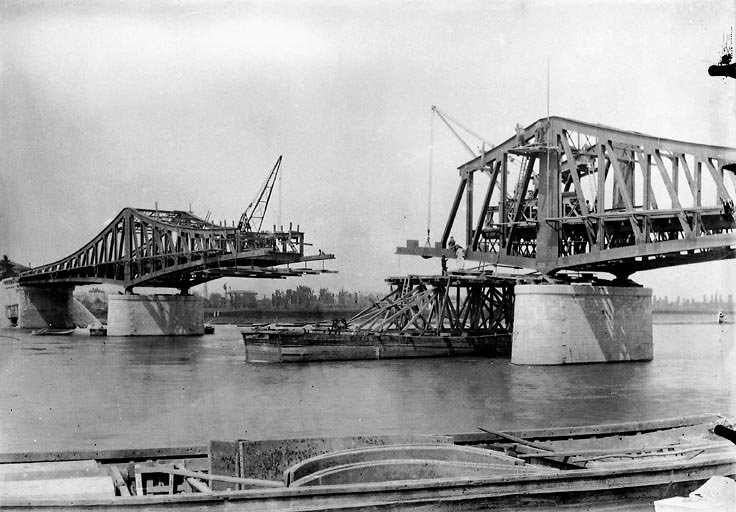 Le pont en construction : pose de la poutre centrale. Photogr. par [Vermorel ?], 1902, plaque de verre.