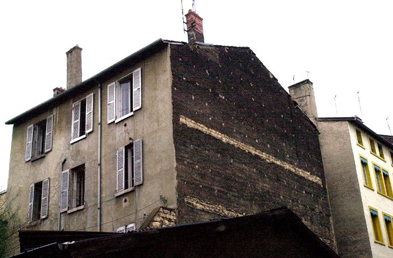 Vue de l'immeuble en fond de cour et de son mur pignon en mâchefer