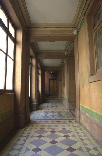 Vue du couloir en fond de bâtiment distribuant les escaliers