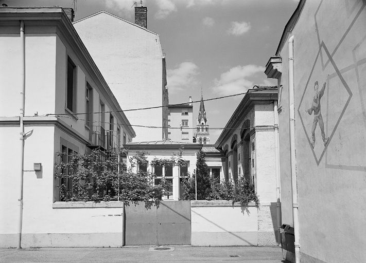 Ecole maternelle : vue des bâtiments prise depuis la cour sud-ouest. A l'arrière-plan, le clocher de l'église Sainte-Blandine