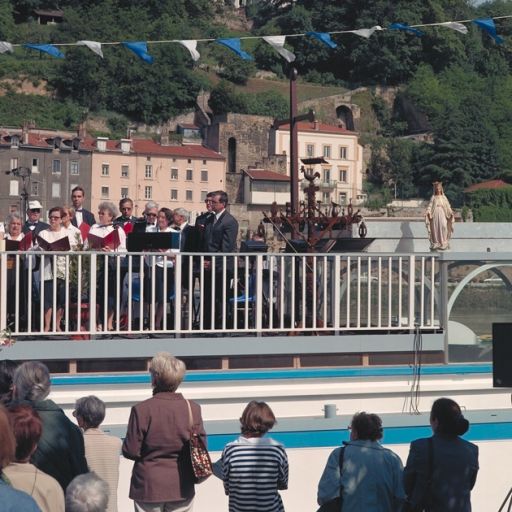 Fête des mariniers. La célébration de la messe sur le pont supérieur du bateau chapelle : la chorale de Sainte-Foy-les-Lyon