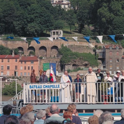 Fête des mariniers. La célébration de la messe sur le pont supérieur du bateau chapelle : les célébrants