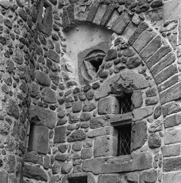 Détail des ouvertures pratiquées dans le petit corps de bâtiment formant le lien entre l'aile ouest et l'église, au 1er étage ; oculus trilobé en remploi, fenêtre au monogramme des La Perrière.