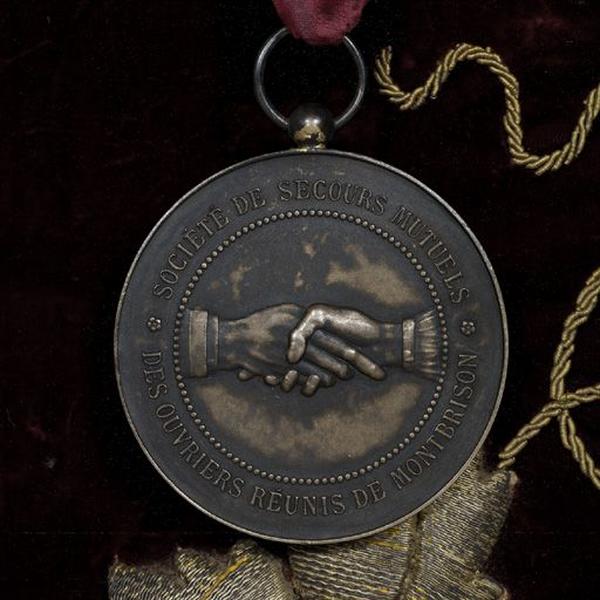 Détail de la médaille fixée au-dessous des mains à droite (face).