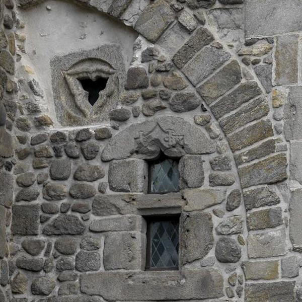 Détail des ouvertures pratiquées dans le petit corps de bâtiment formant le lien entre l'aile ouest et l'église, au 1er étage ; oculus trilobé en remploi, fenêtre au monogramme des La Perrière.