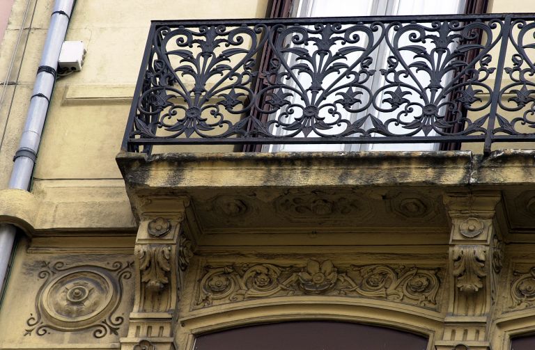 Façade principale, balcon du quatrième étage, sculptures et ferronnerie.