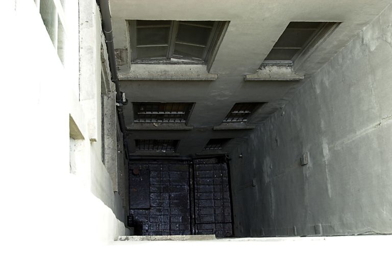 Cour à l'arrière du 1er corps de bâtiment prise depuis l'escalier. A droite, corps de galeries aux ouvertures murées séparant les deux cours.
