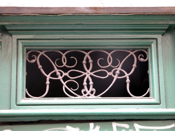 Façade principale, porte, détail du tympan de menuiserie.