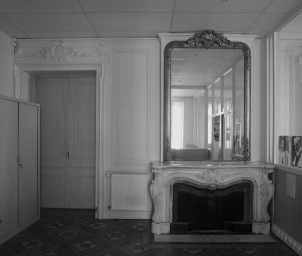 Ancien appartement du curé, grand salon, porte vers le hall et cheminée.