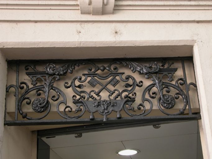 Façade place Antoine-Rivoire, ancienne porte, tympan de ferronnerie aux armes du chapitre de Saint-Nizier.