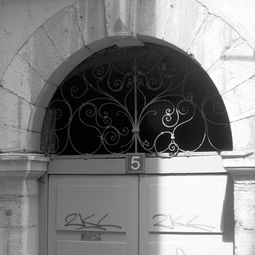 Façade, porte, détail du tympan de ferronnerie.