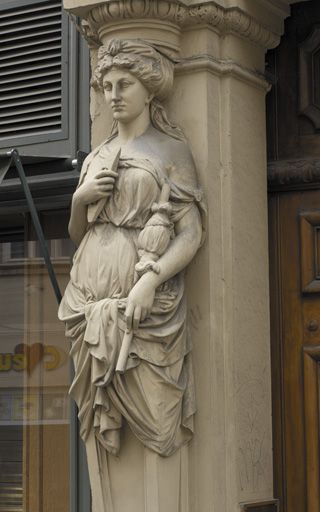 Façade principale, porte, terme de gauche, allégorie du tissu.