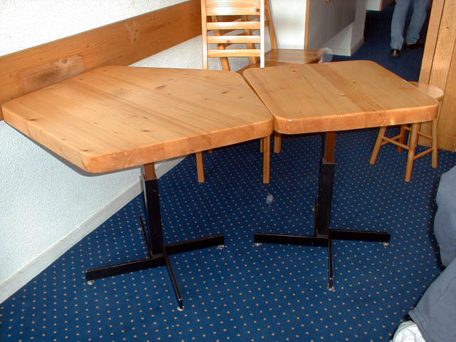 Intérieur d'un appartement, mobilier : table, plateau bois et pied métallique.