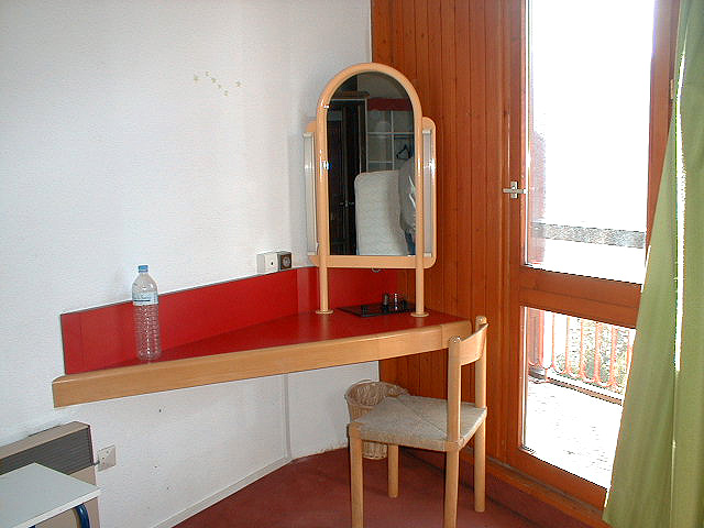Une chambre client (non restaurée) : tablette, miroir et chaise.