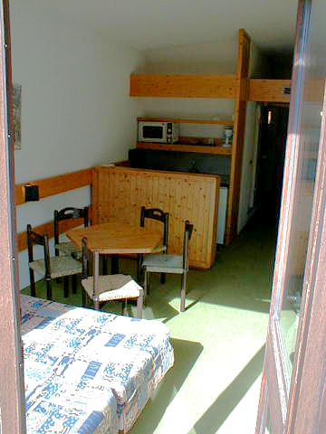 Un studio : entrée, bloc cuisine et coin repas.