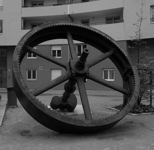 Volant de machine à vapeur de l'usine Rhodiaceta exposé rue Cassin