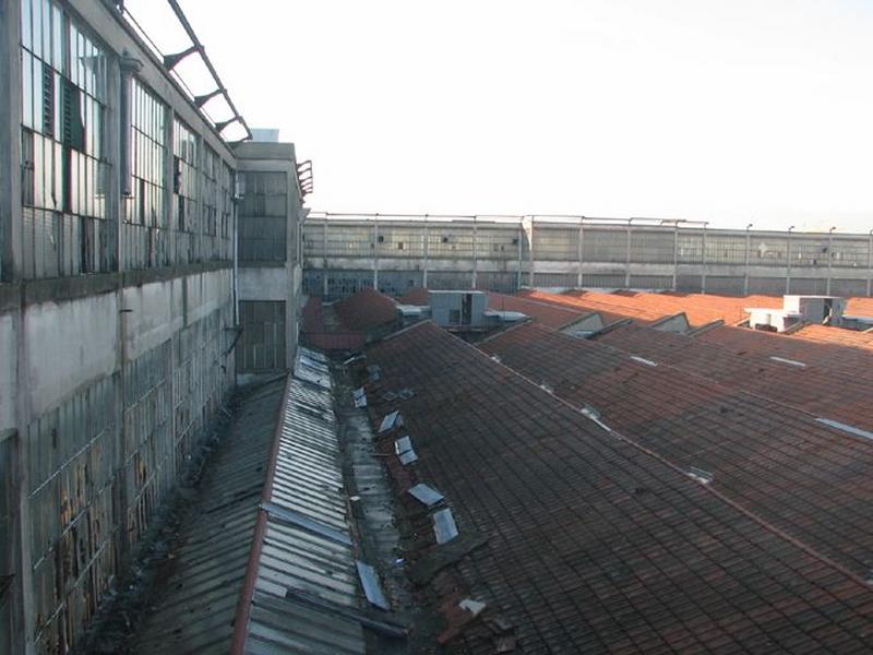 Vue d'ensemble toiture shed des ateliers en rez-de-chaussée, aile en béton et bâtiment principal