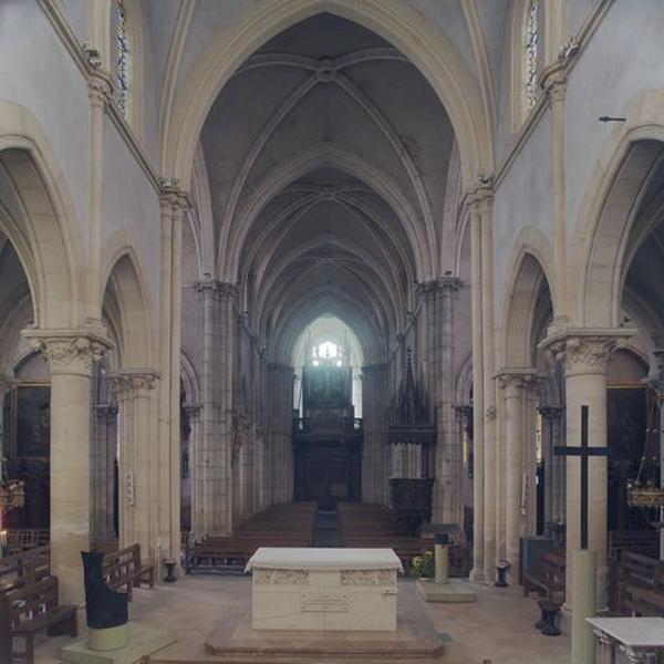 Vue intérieure de l'église depuis le choeur en direction de l'entrée, avec les verrières et la chaire à prêcher.