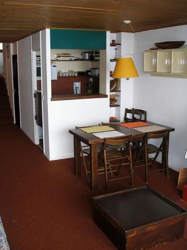 Appartement traversant sur 2 demi-niveaux. Le coin-repas et le passe-plat formant séparation avec la cuisine. Mobilier d'origine dessiné par Monique Labro