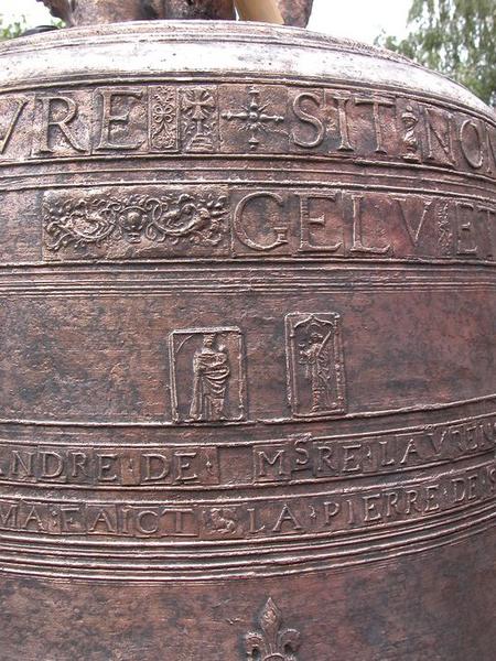 Cloche (n°1), détail de plaquettes avec caractères et représentations figurées : Vierge à l'Enfant aux côtés de saint Jean.