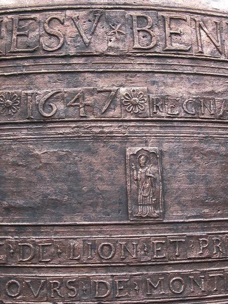 Cloche (n°1), détail de plaquettes avec caractères, date et médaillon rectangulaire représentant un saint évêque bénissant.