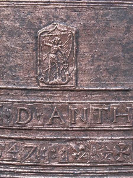 Cloche (n°1), détail de plaquettes avec caractères et un médaillon rectangulaire représentant saint Michel terrassant le dragon.
