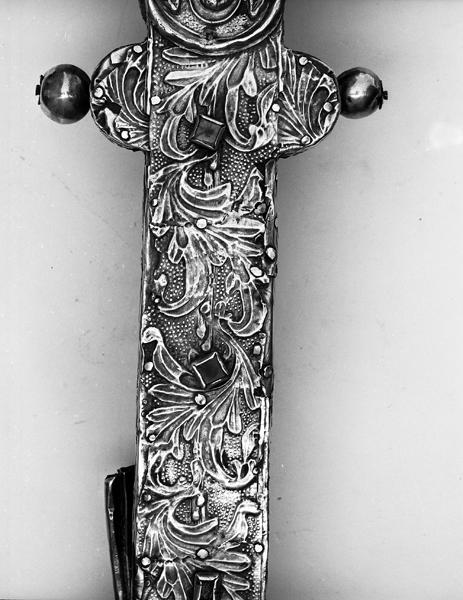 Croix de procession, revers, détail, bas du montant, au-dessus du quadrilobe : feuillages estampés.